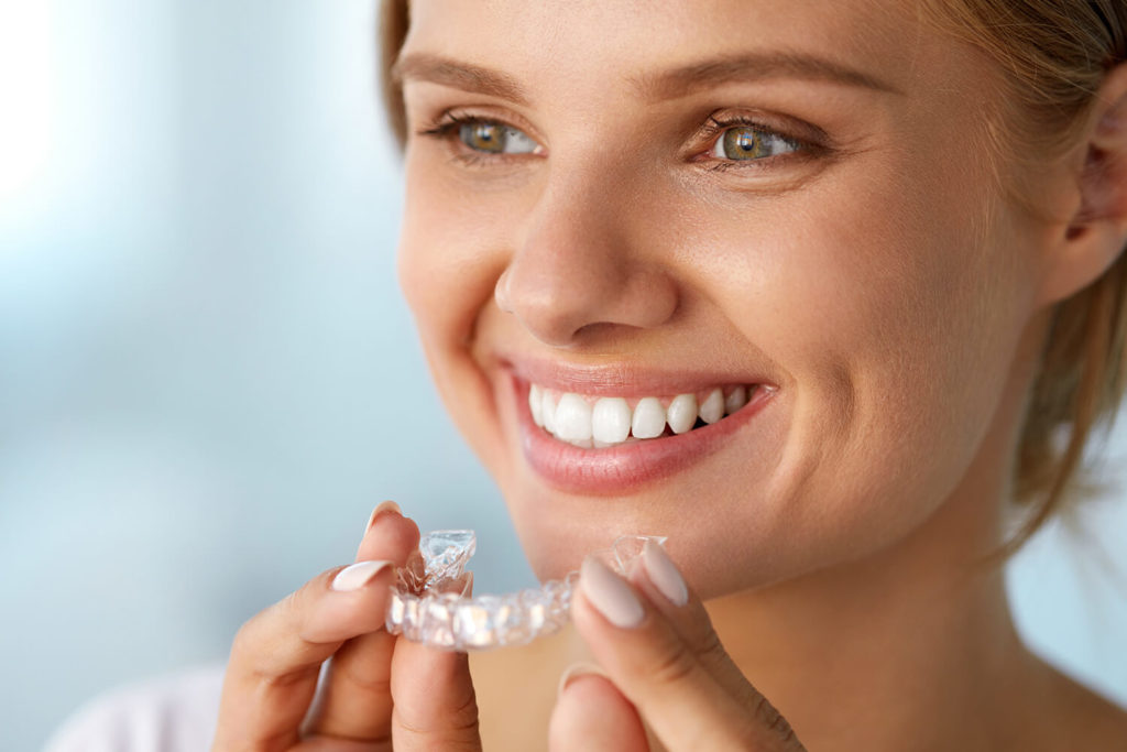 woman smiling with invisalign retainer