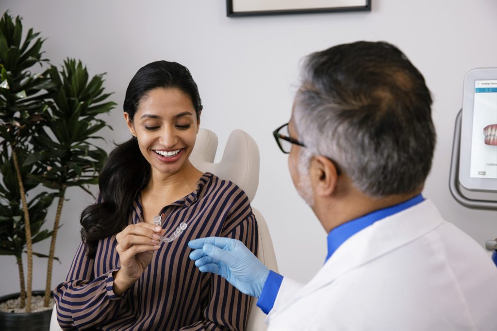 orthodontist giving teenage girl patient invisalign aligner